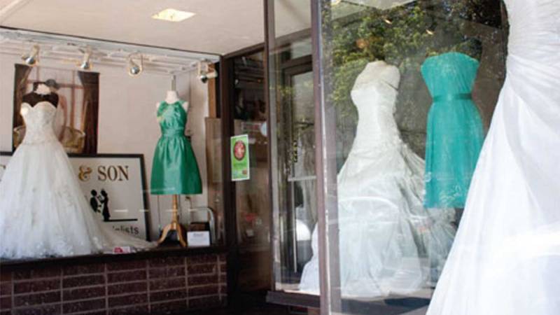 Wedding attire shop windows with wedding dresses displayed.