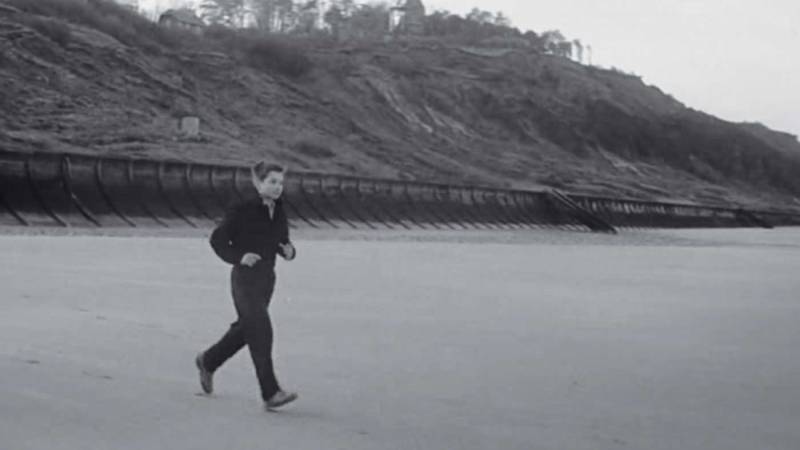 Scene from “400 Blows” of a boy running across a beach.