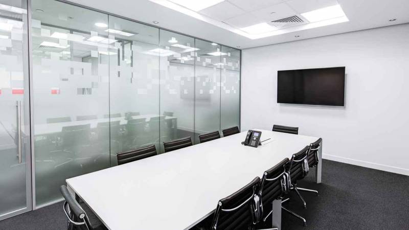 Photo of a modern office meeting room with lots of reflective surfaces.
