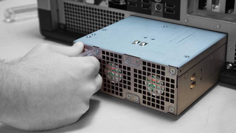 A person installing a power supply in a computer.