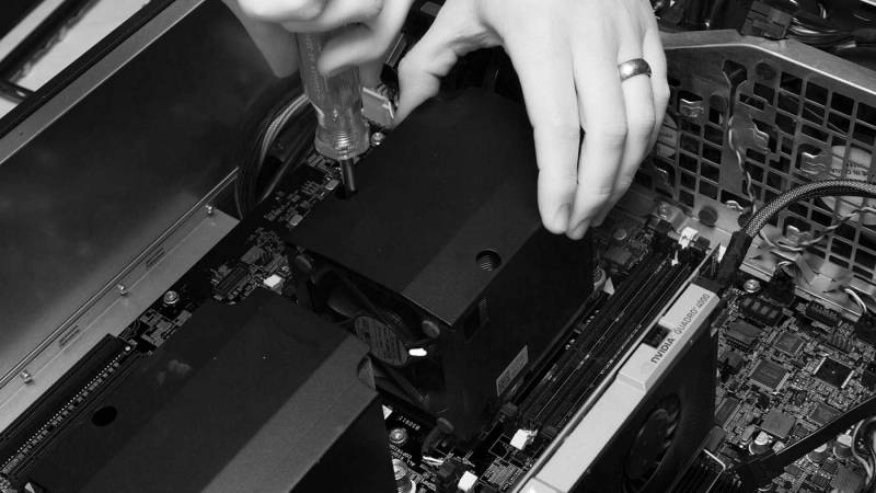 A person installing a heat sink in a computer.