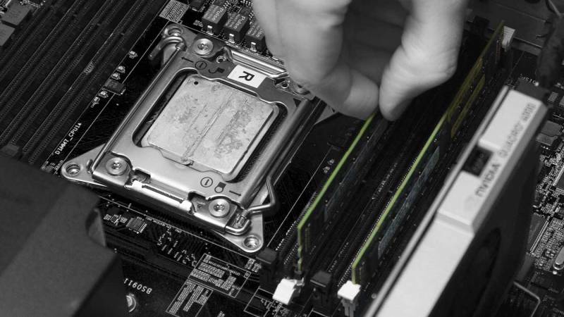A person installing RAM in a computer.