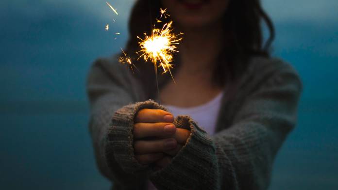 380-C03-Lighting-primary Person holding a sparkler to light a night scene.