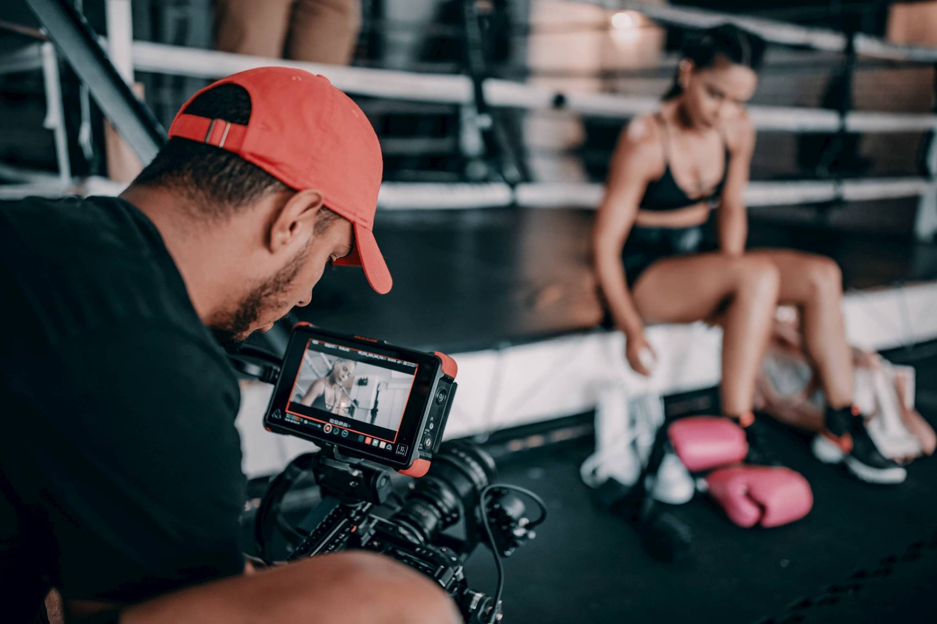 man in foreground with camera pointed at a boxer in the background