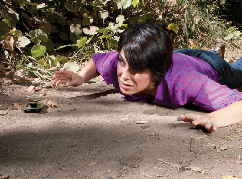 A collage of shots showing a woman walking then tripping over a rock and falling.