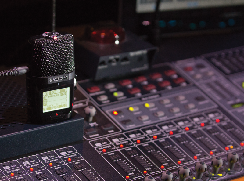 A Zoom audio recorder on a mixer board