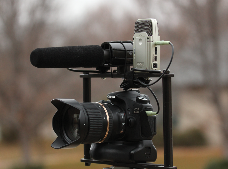 A Canon EOS 60D camera on a rig with a Zoom recorder and a shotgun mic