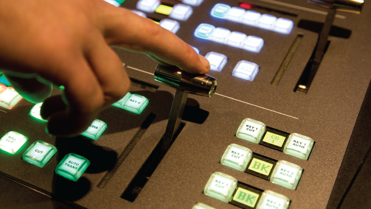 A hand is poised to make the switch using the t-bar of a switcher