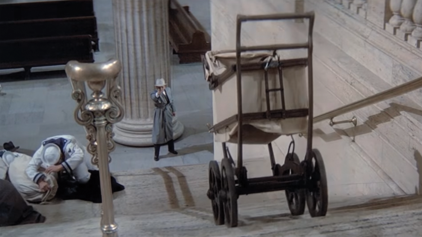 Baby carriage traveling down the stairs, right into the path of gun fire. 